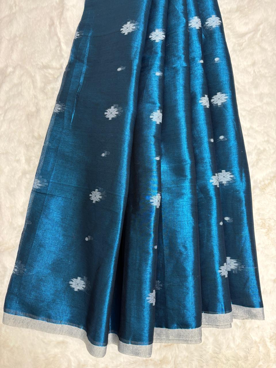 Blue fabric with white floral patterns on a light gray background