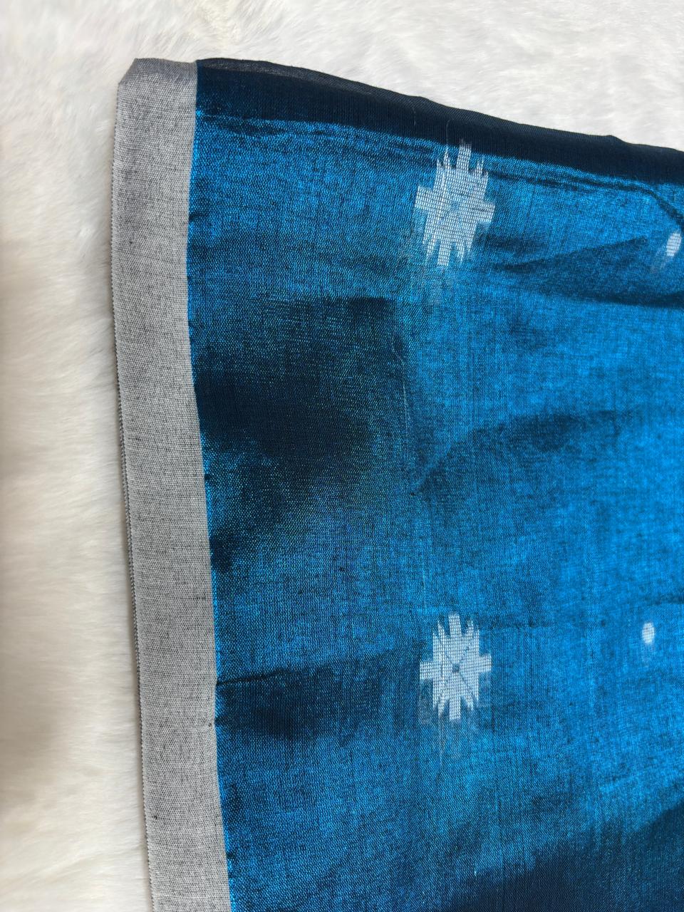 Blue fabric with white floral patterns on a textured light gray background