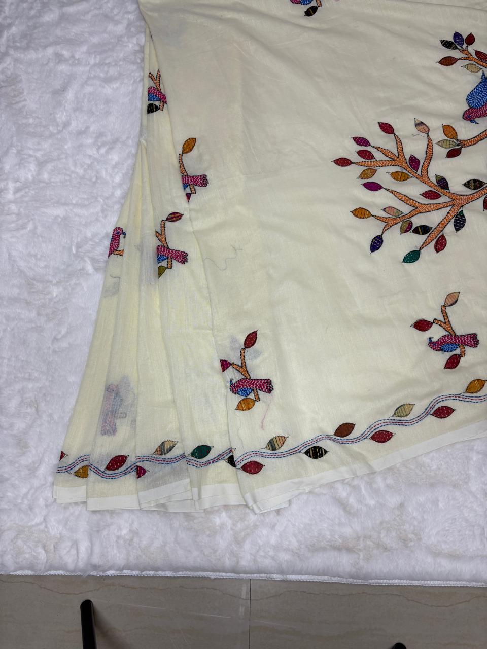 White fabric with colorful embroidery on a textured white background
