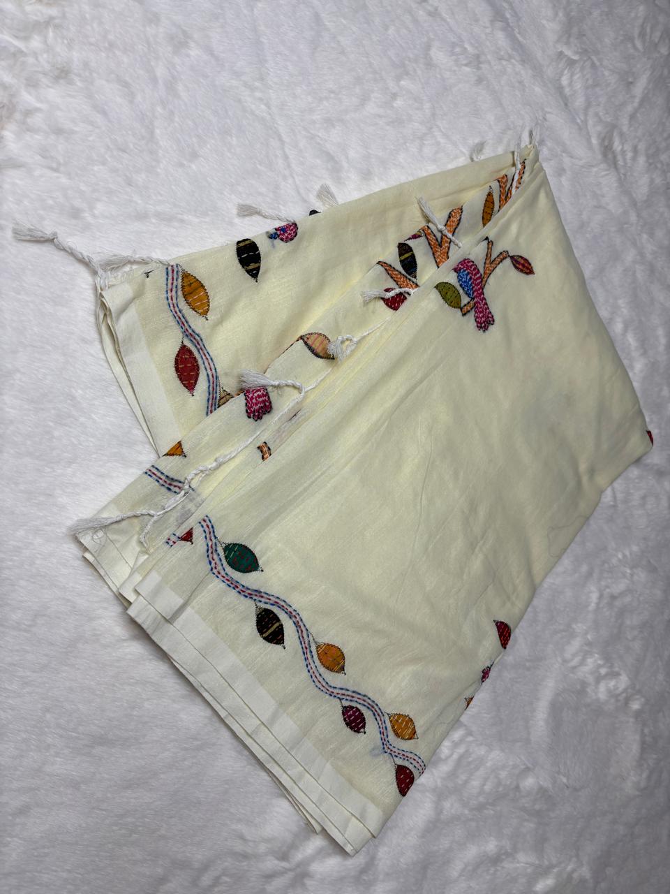 White fabric with colorful embroidery on a textured white background