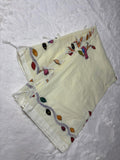 White fabric with colorful embroidery on a textured white background