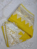 Yellow saree with white border on a textured surface