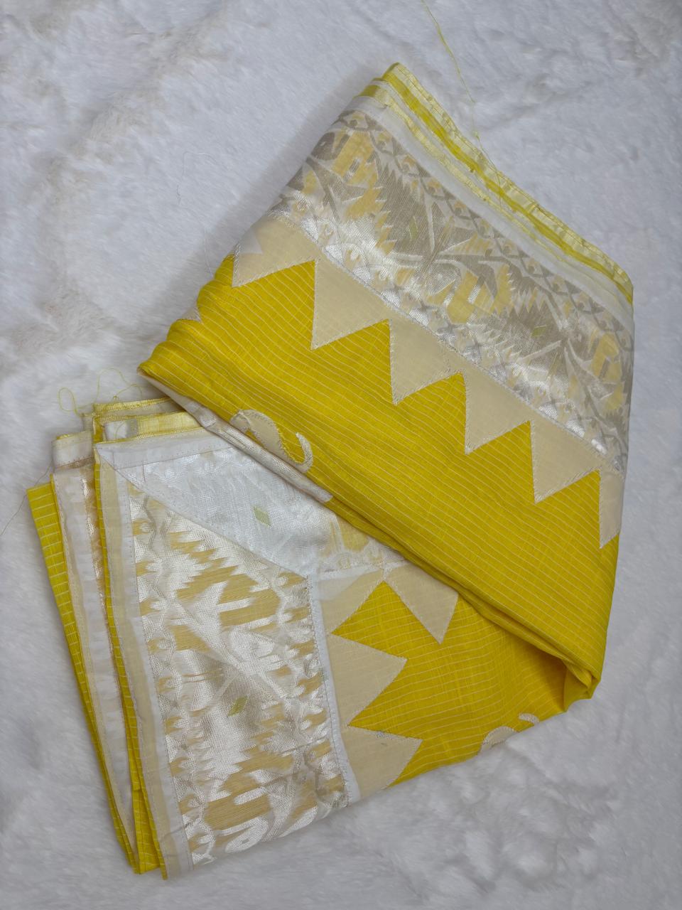 Yellow saree with white border on a textured surface