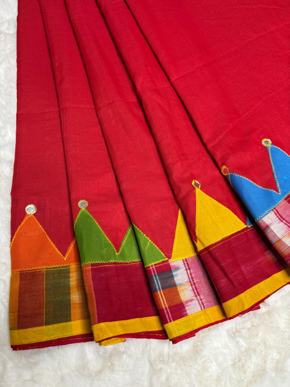 Red saree with colorful geometric patterns on a white background