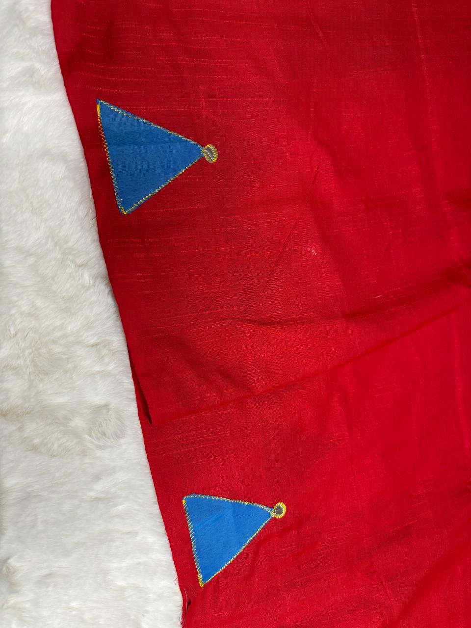 Red fabric with blue triangle patterns on a white background
